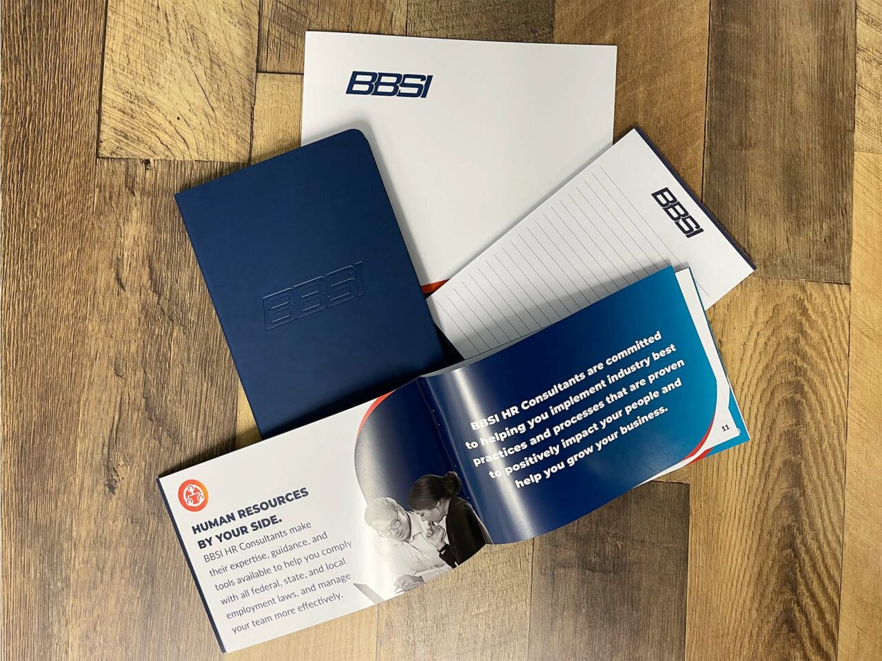 Example of Morel's print capabilities, showing a branded folder, notepad, notebook, and booklet for their client, BBSI.