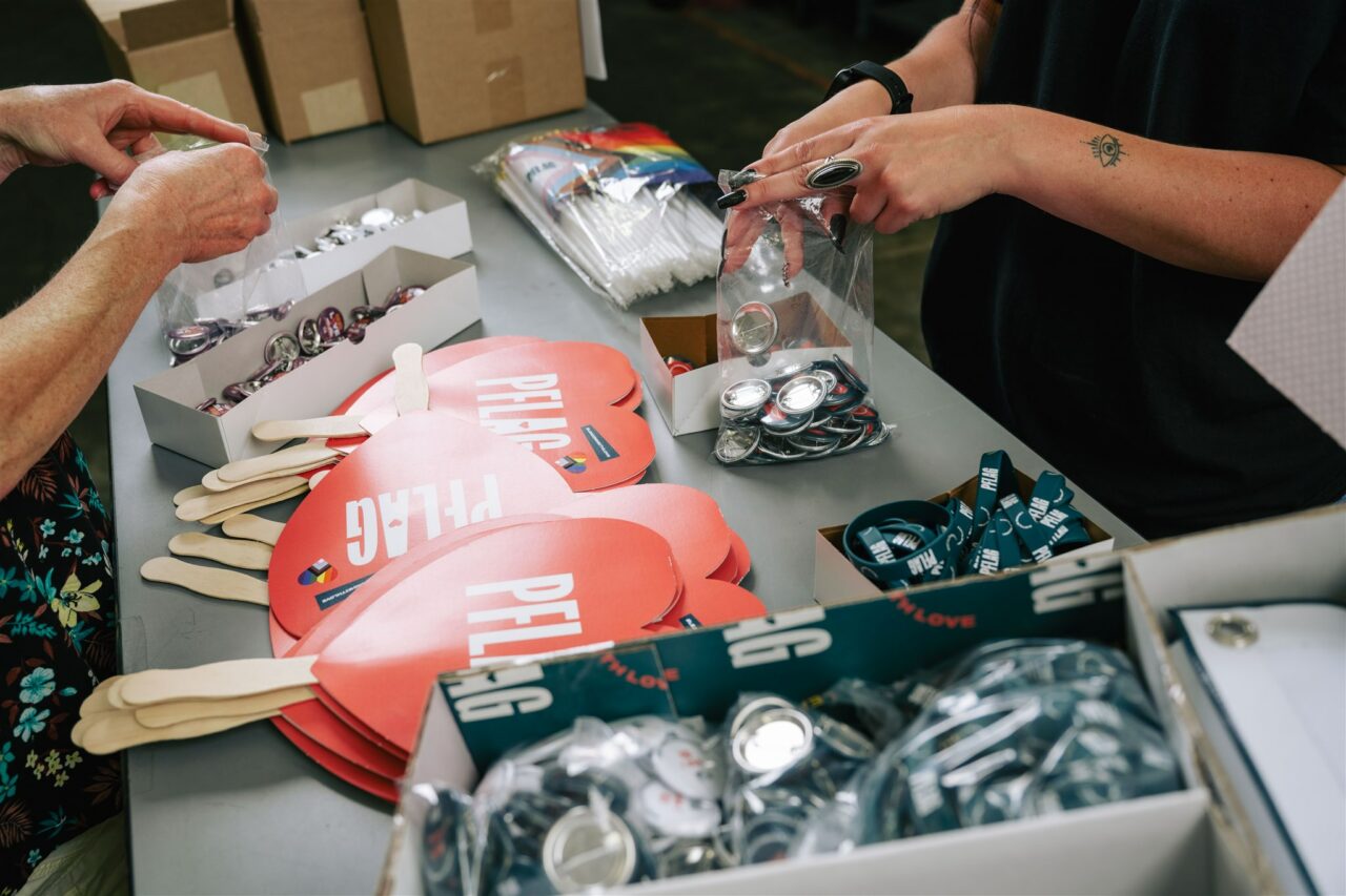 An example of Morel's packaging, promotional, and fulfillment capabilities showing signs, buttons, and wristbands for their client, PFLAG